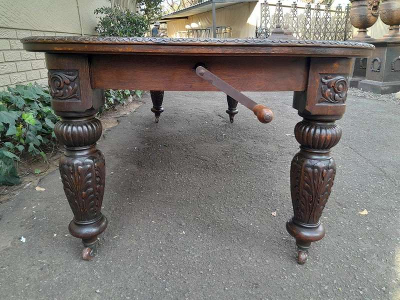 An Antique Victorian English Carved Oak Extending Dining Table on Castors and with Crank Handle