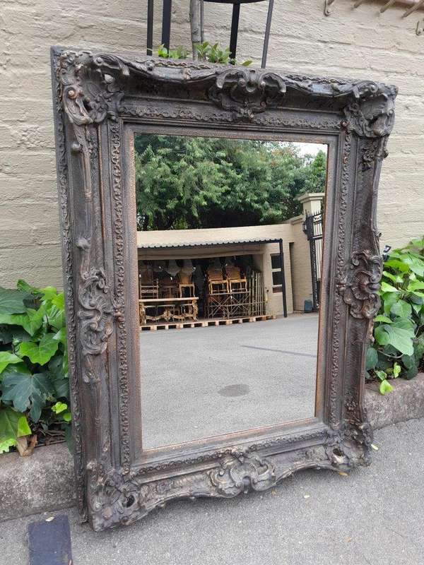 A 20th Century French Style Heavily Carved And Gilded Mirror
