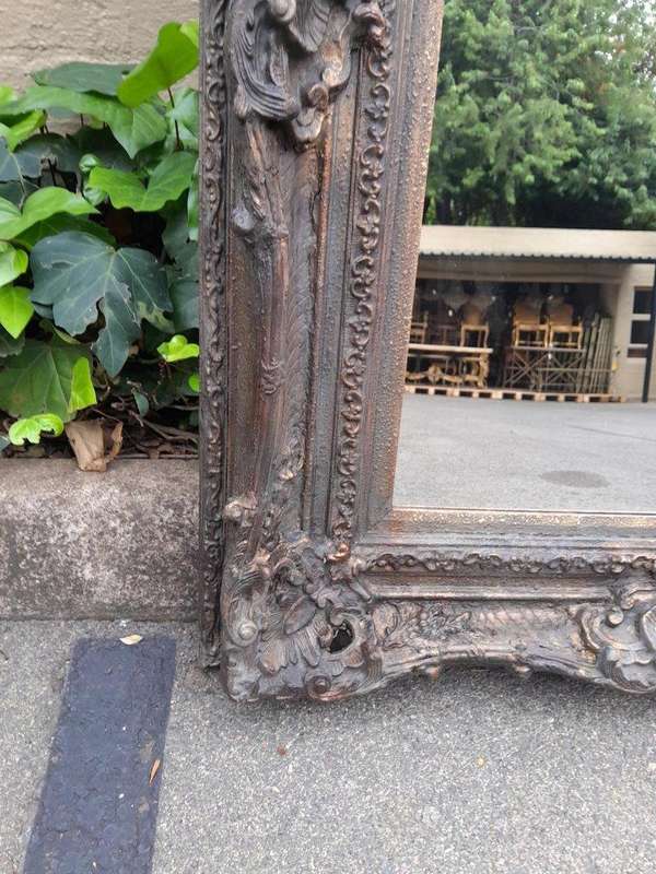A 20th Century French Style Heavily Carved And Gilded Mirror