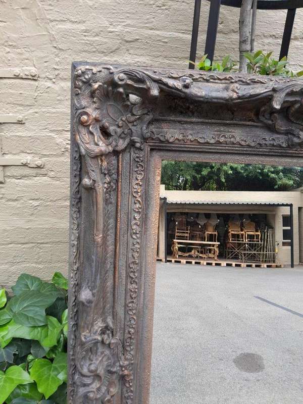 A 20th Century French Style Heavily Carved And Gilded Mirror