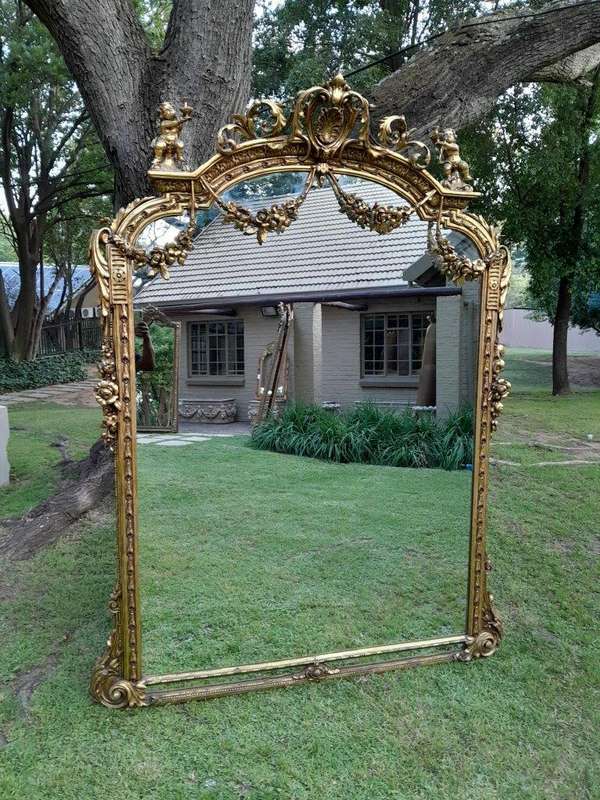 A French Style Ornately Carved And Gilded Bevelled Mirror Of Large Proportions