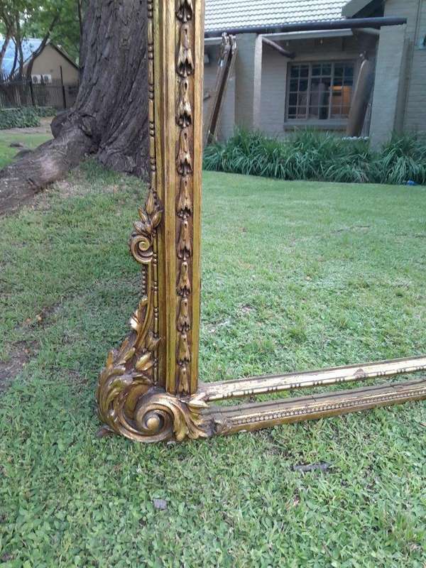 A French Style Ornately Carved And Gilded Bevelled Mirror Of Large Proportions