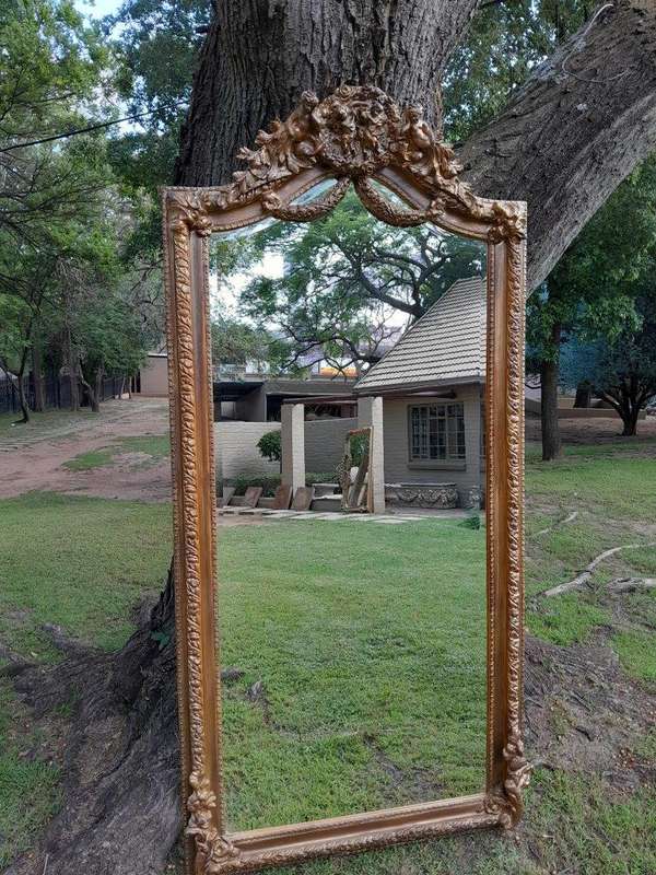 A French Rococo Style Ornately Carved And Gilded Bevelled Mirror