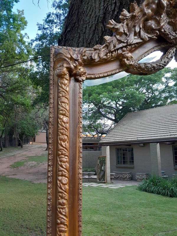 A French Rococo Style Ornately Carved And Gilded Bevelled Mirror