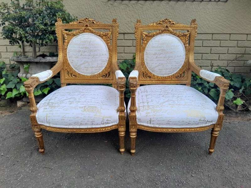 A 20th Century Pair Of French Ornately Carved And Gilded Armchairs