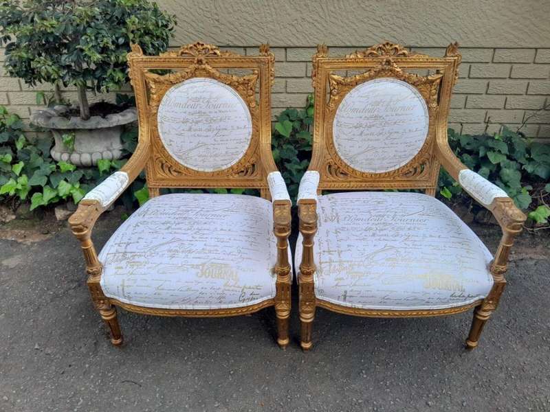 A 20th Century Pair Of French Ornately Carved And Gilded Armchairs