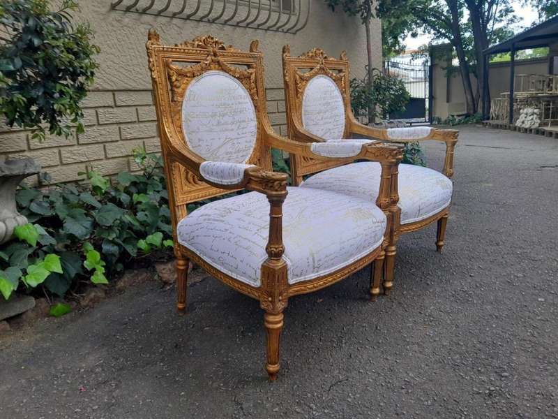 A 20th Century Pair Of French Ornately Carved And Gilded Armchairs