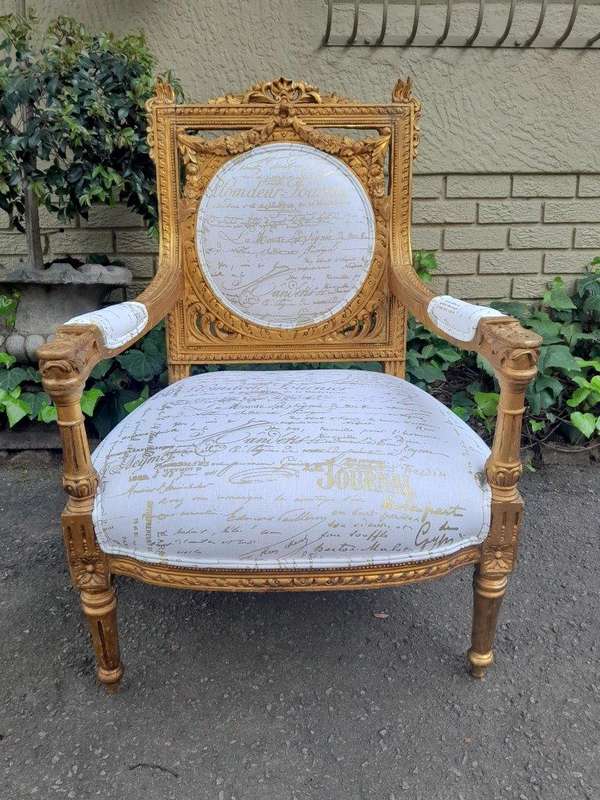 A 20th Century Pair Of French Ornately Carved And Gilded Armchairs