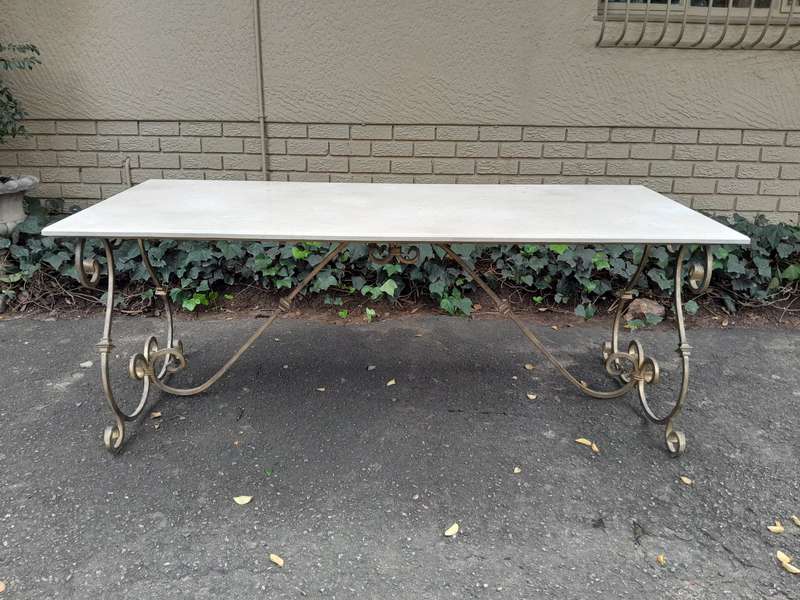A  French Style Wrought Iron Console / Dining Table in an Antique Gold Finish with Cream Marble T...