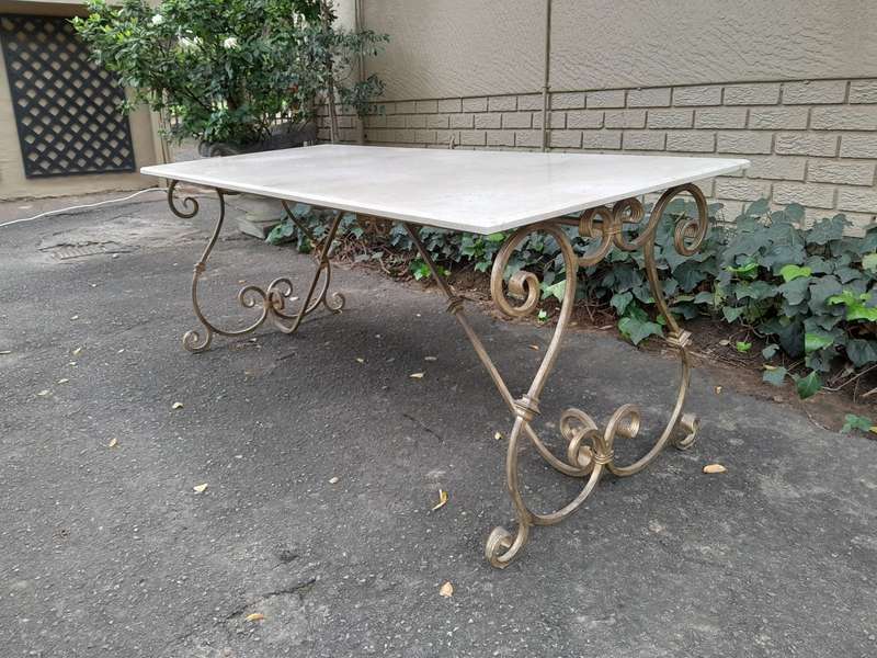 A  French Style Wrought Iron Console / Dining Table in an Antique Gold Finish with Cream Marble T...