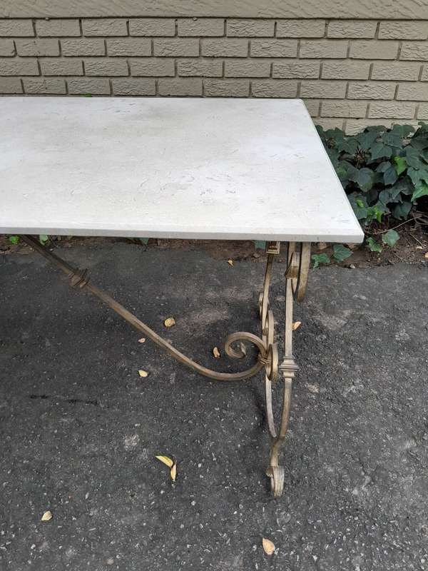 A  French Style Wrought Iron Console / Dining Table in an Antique Gold Finish with Cream Marble T...