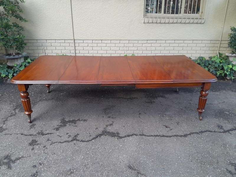 An Antique Edwardian Extending Dining Table with Heavily Carved Legs on Castors and with Crank Ha...