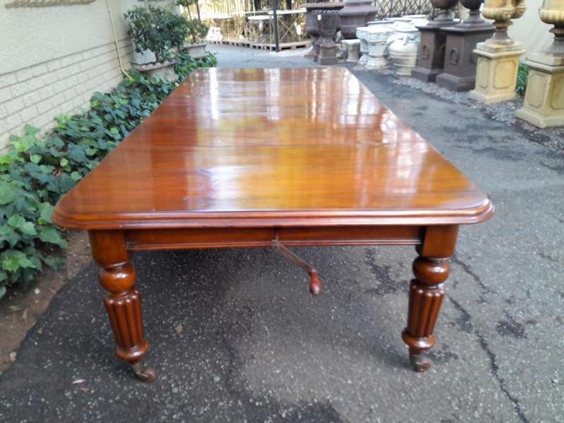 An Antique Edwardian Extending Dining Table with Heavily Carved Legs on Castors and with Crank Ha...