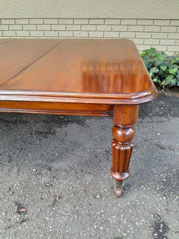 An Antique Edwardian Extending Dining Table with Heavily Carved Legs on Castors and with Crank Ha...