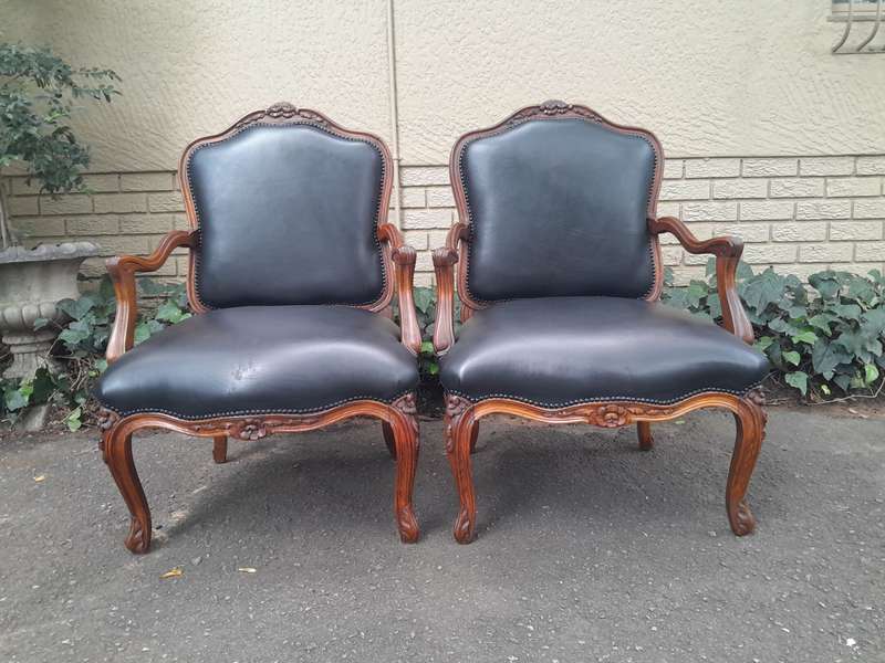 A 20th Century Pair or Carved Mahogany Armchairs Upholstered In Leather
