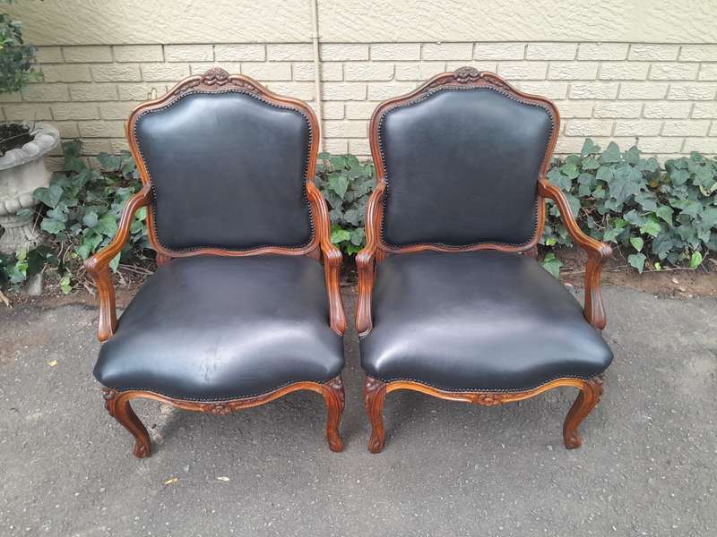 A 20th Century Pair or Carved Mahogany Armchairs Upholstered In Leather