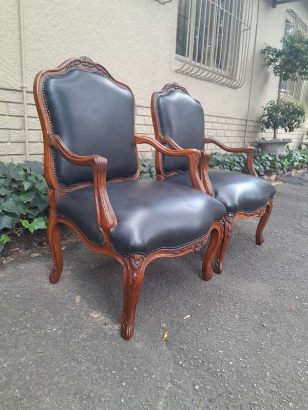 A 20th Century Pair or Carved Mahogany Armchairs Upholstered In Leather