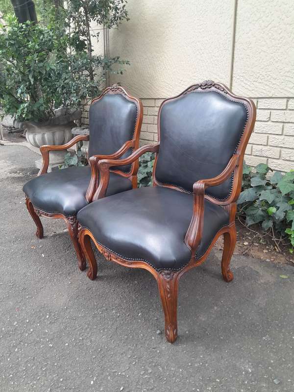 A 20th Century Pair or Carved Mahogany Armchairs Upholstered In Leather