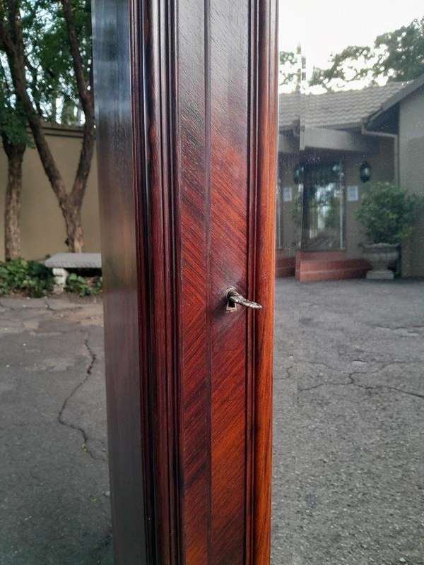 An Early 20th Century French Carved Rosewood Armoire with Bevelled Mirror and Lock and Key