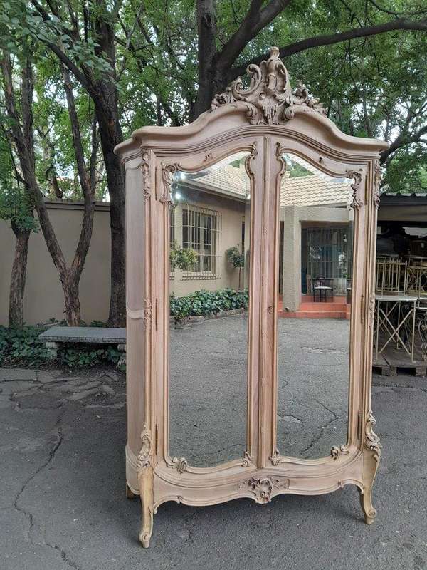 An Antique French Heavily Carved Oakd Two Door Armoire with Bevelled Mirrors and Four Shelves