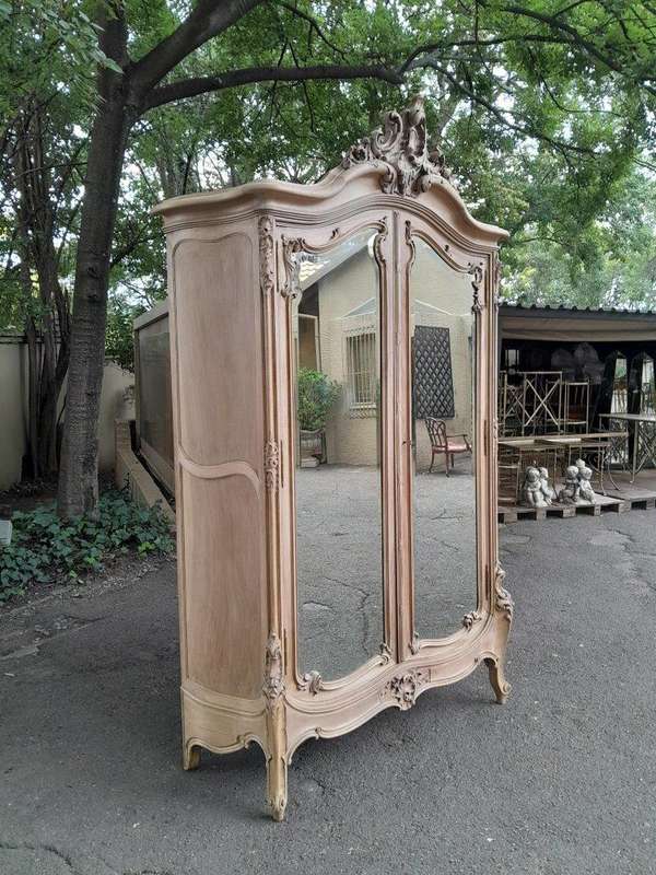 An Antique French Heavily Carved Oakd Two Door Armoire with Bevelled Mirrors and Four Shelves