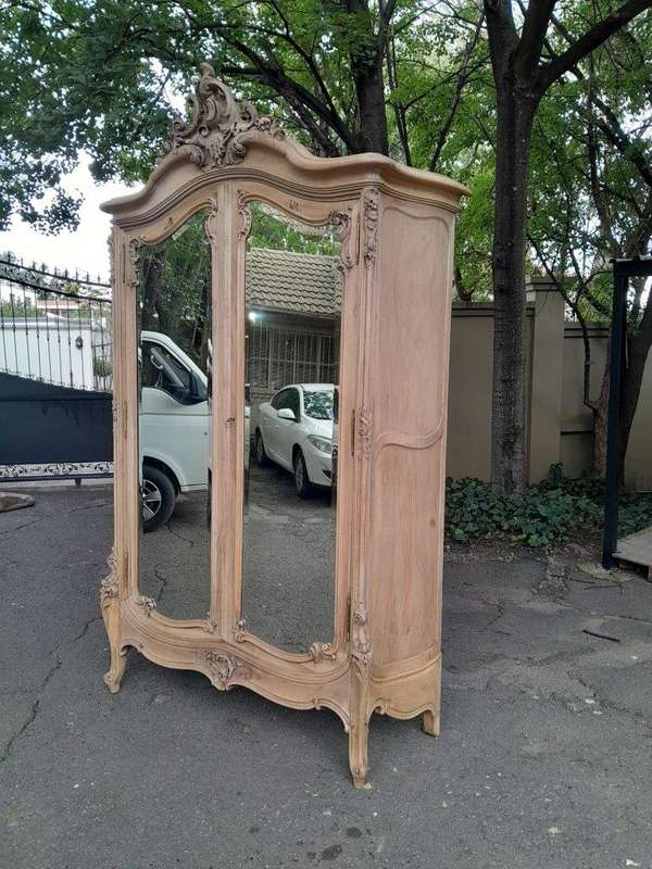 An Antique French Heavily Carved Oakd Two Door Armoire with Bevelled Mirrors and Four Shelves