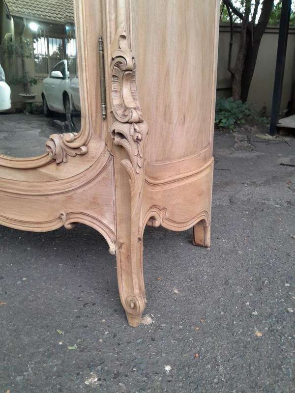 An Antique French Heavily Carved Oakd Two Door Armoire with Bevelled Mirrors and Four Shelves