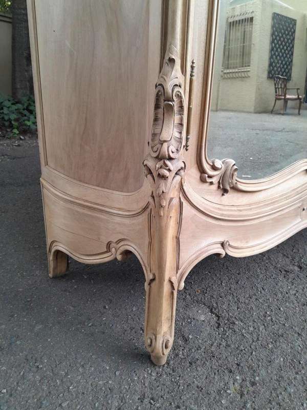 An Antique French Heavily Carved Oakd Two Door Armoire with Bevelled Mirrors and Four Shelves