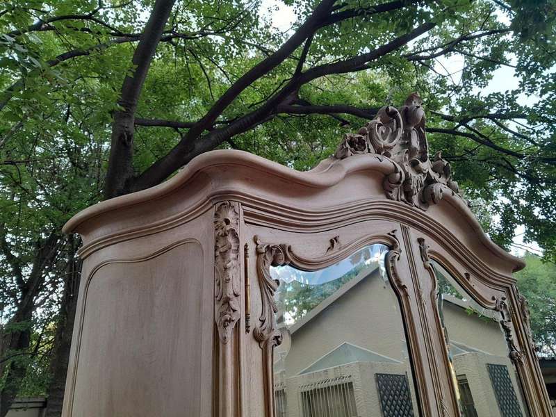 An Antique French Heavily Carved Oakd Two Door Armoire with Bevelled Mirrors and Four Shelves