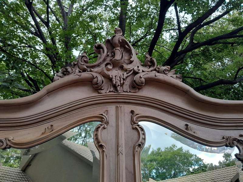 An Antique French Heavily Carved Oakd Two Door Armoire with Bevelled Mirrors and Four Shelves