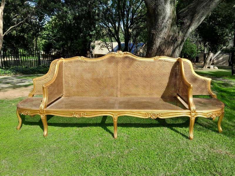 A 20th Century French Style Carved and Gilded Conversation Settee in Rattan