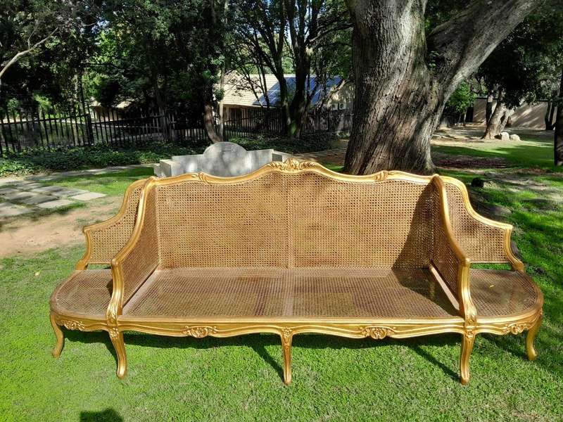 A 20th Century French Style Carved and Gilded Conversation Settee in Rattan
