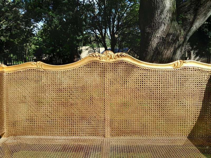 A 20th Century French Style Carved and Gilded Conversation Settee in Rattan
