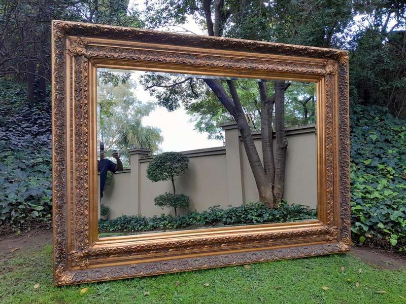 A 20th Century Heavily Carved And Bevelled Framed Mirror Of Large Proportions