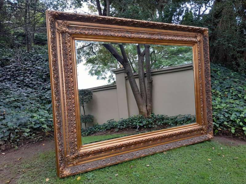 A 20th Century Heavily Carved And Bevelled Framed Mirror Of Large Proportions