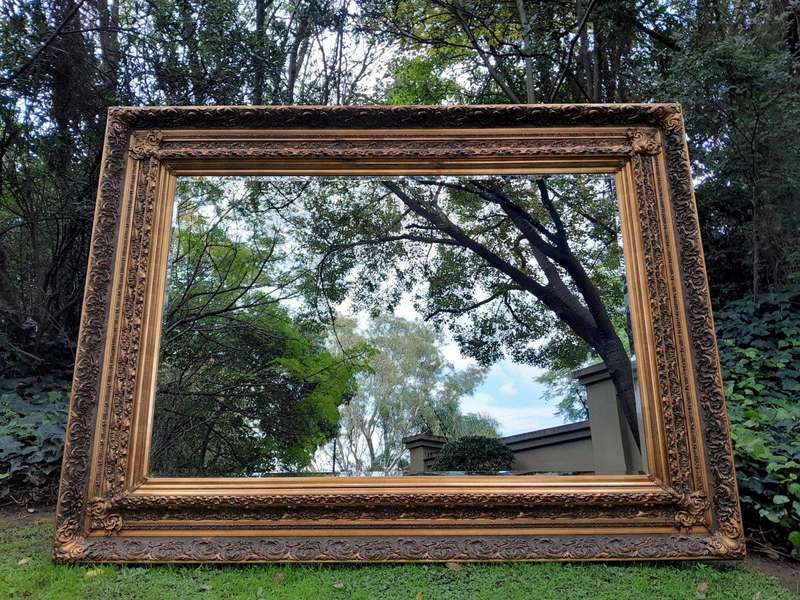 A 20th Century Heavily Carved And Bevelled Framed Mirror Of Large Proportions