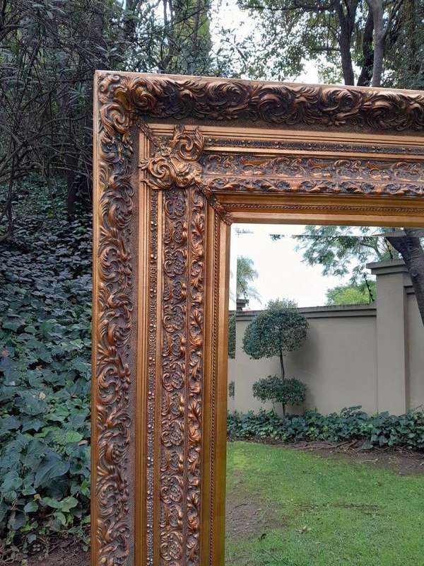 A 20th Century Heavily Carved And Bevelled Framed Mirror Of Large Proportions