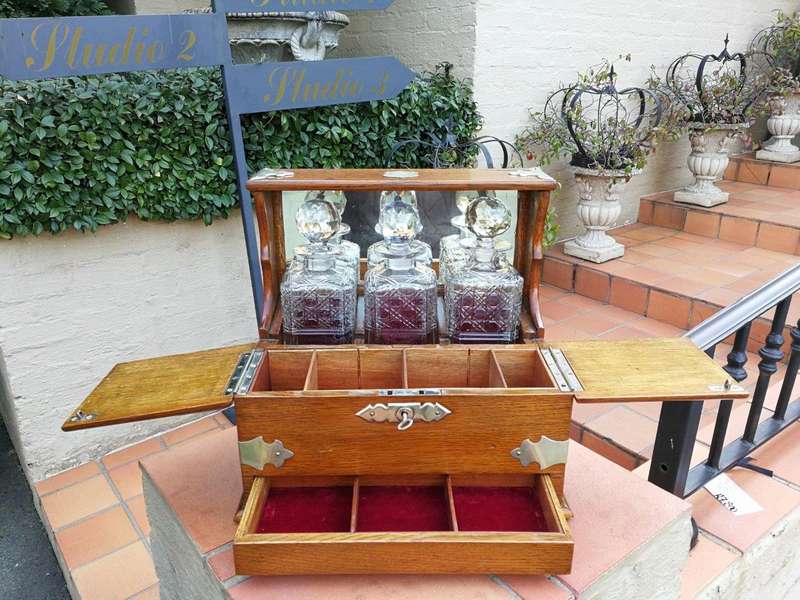 An Oak Tantalus With Silver Plate Fittings And Three Decanters With Key And Secret Drawer ND