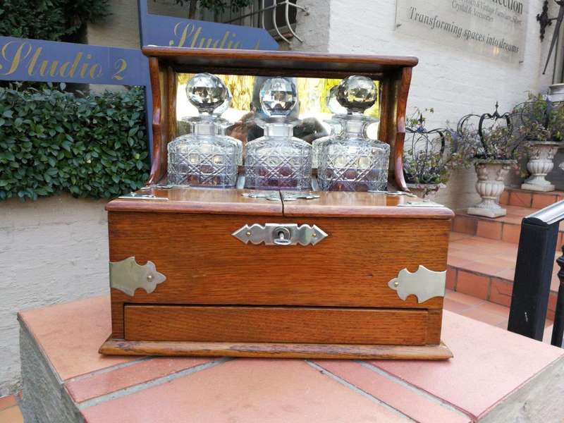 An Oak Tantalus With Silver Plate Fittings And Three Decanters With Key And Secret Drawer ND