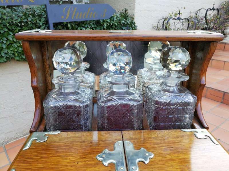 An Oak Tantalus With Silver Plate Fittings And Three Decanters With Key And Secret Drawer ND