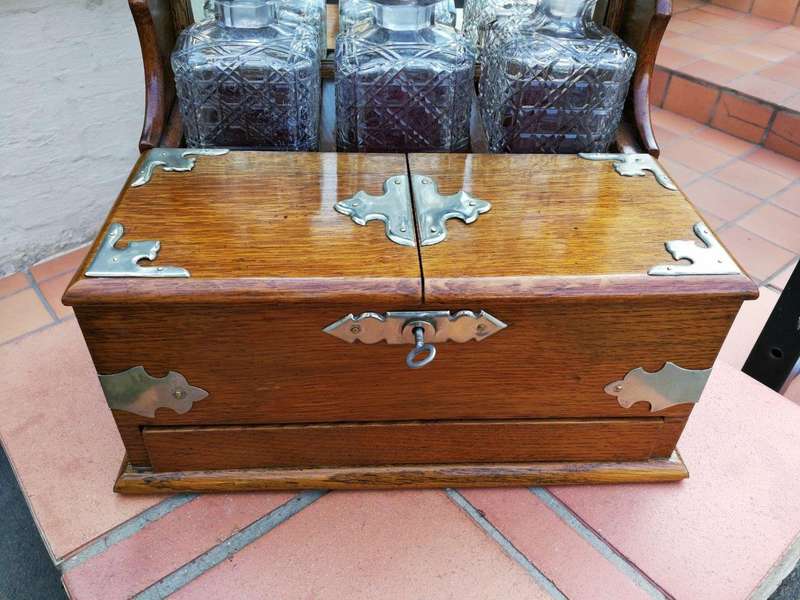 An Oak Tantalus With Silver Plate Fittings And Three Decanters With Key And Secret Drawer ND