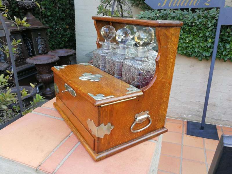An Oak Tantalus With Silver Plate Fittings And Three Decanters With Key And Secret Drawer ND