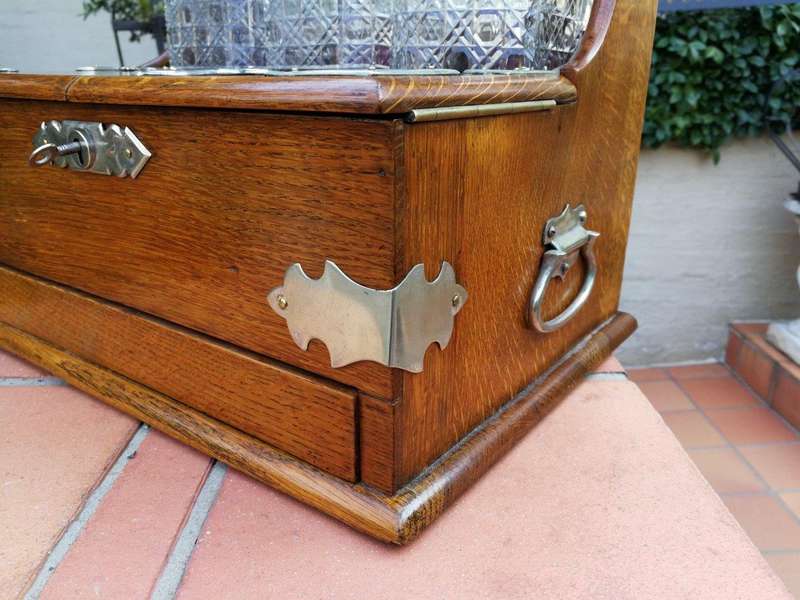 An Oak Tantalus With Silver Plate Fittings And Three Decanters With Key And Secret Drawer ND