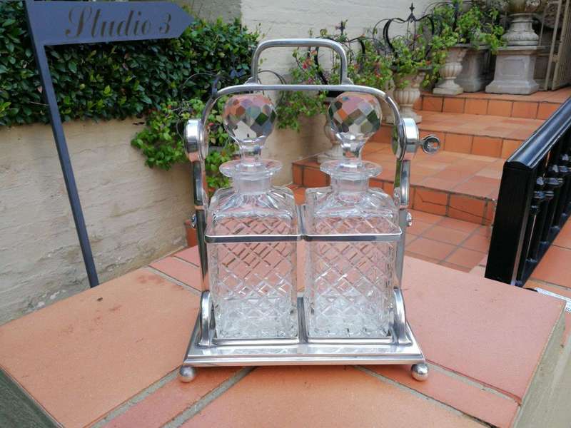 A Silver- Plate Tantalus With Two Cut-Glass Decanters