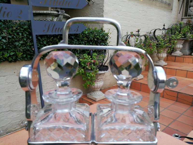 A Silver- Plate Tantalus With Two Cut-Glass Decanters