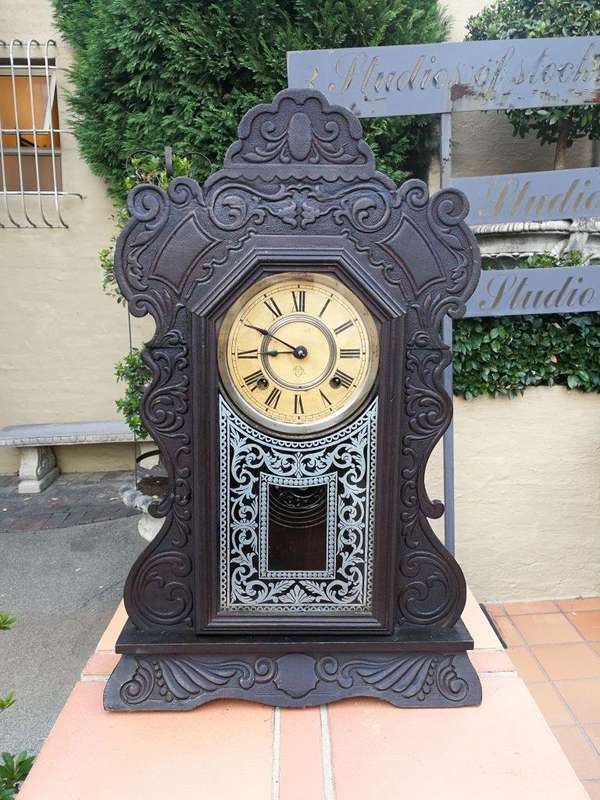 An Early 20th Century American Ebonised & Ornate Carved Oak Mantel Clock