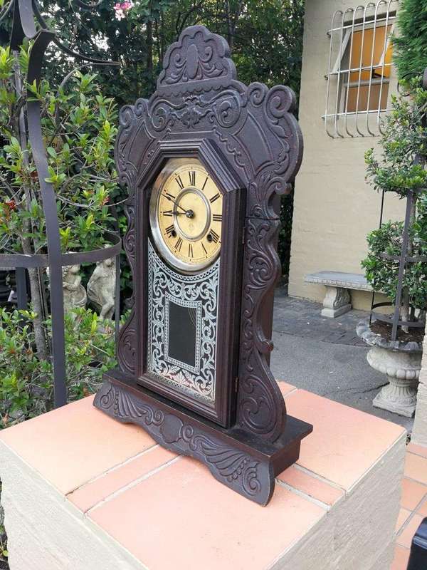 An Early 20th Century American Ebonised & Ornate Carved Oak Mantel Clock