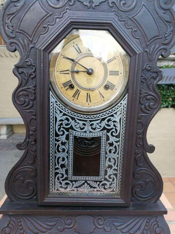 An Early 20th Century American Ebonised & Ornate Carved Oak Mantel Clock