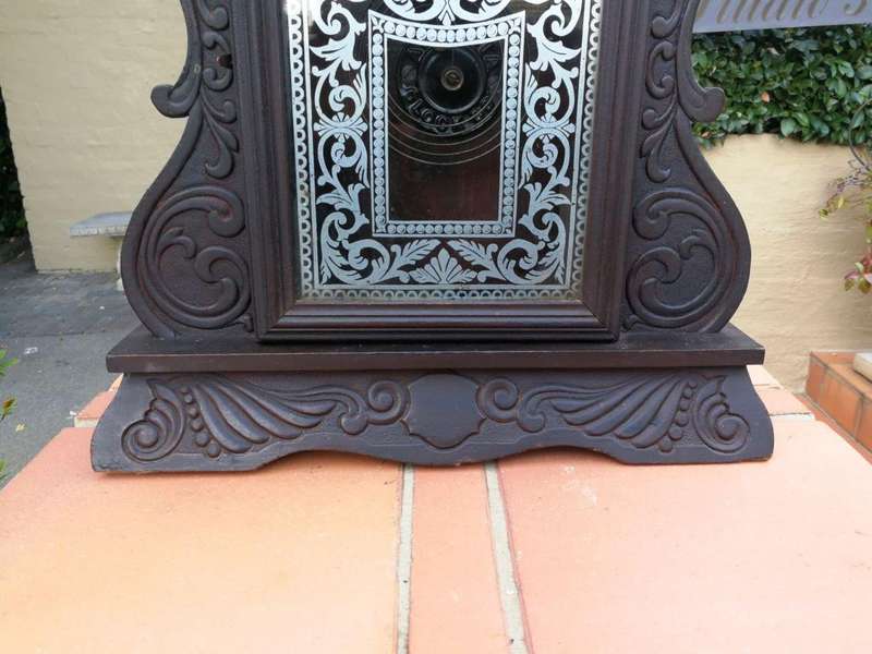 An Early 20th Century American Ebonised & Ornate Carved Oak Mantel Clock