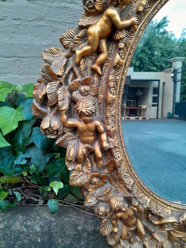 A 20th Century Baroque Style Heavily Carved And Ornate Gilt-Framed Bevelled Glass Mirror